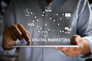 What is digital marketing? Illustration of a person using a tablet with digital marketing icons representing SEO, social media, email marketing, mobile marketing, video marketing, and online advertising